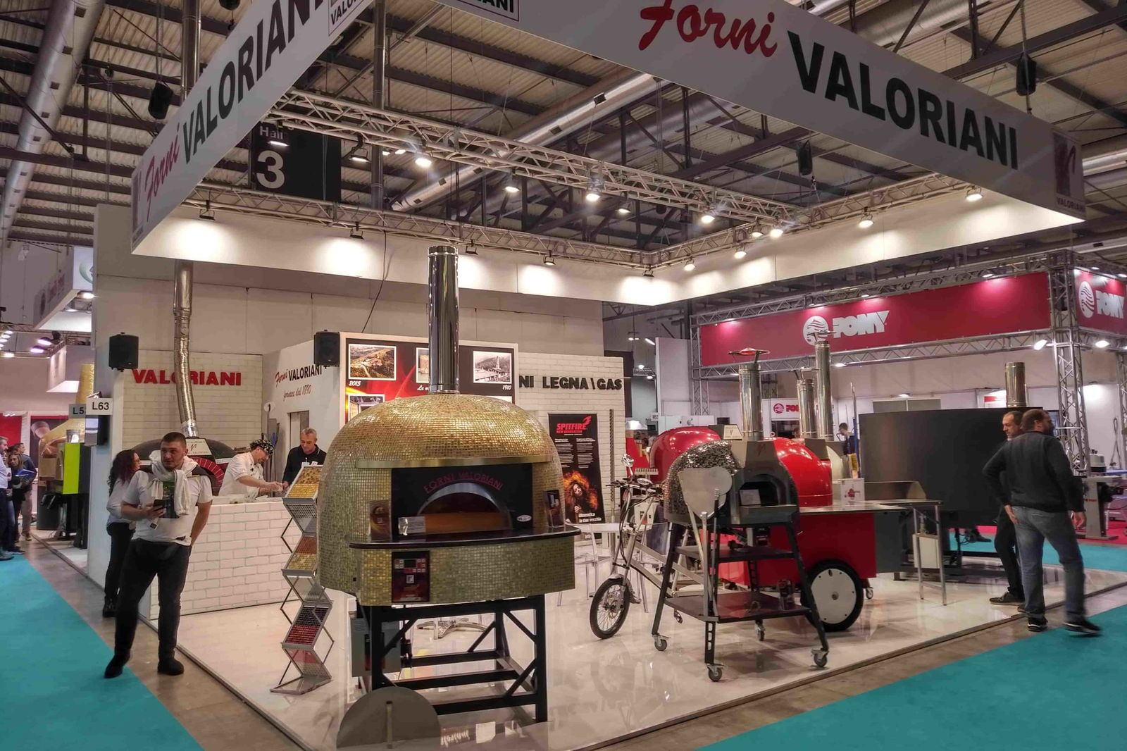 Ein attraktiver Messestand von Valoriani Forni, der modernes Design und hochwertige Materialien präsentiert, ideal für die Vorstellung von handgefertigten Öfen und kulinarischen Erlebnissen.